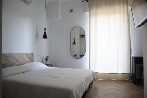 1 dormitorio con cama blanca y espejo en CasaValentina en Roma