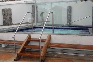 una piscina con 2 bancos en un edificio en Pousada Relíquias do Tempo, en Diamantina