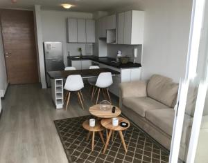 a living room and kitchen with a couch and a table at Departamento Pacífico 2800-Reserva Mínima de 3 días in La Serena