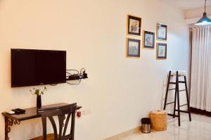 uma sala de estar com uma televisão na parede em Aashianaa Gracious Living em Nova Deli