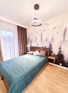 1 dormitorio con 1 cama con edredón azul en LAGUNA Apartament Polanica Residence 41, en Polanica-Zdrój