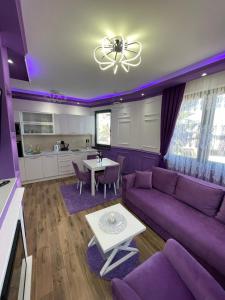 a purple living room with a purple couch and a table at VIOLET QUEEN in Kopaonik