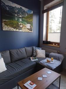 a living room with a couch and a table at Apartament MOKKA SILVER Basen-Sauna-Jacuzzi in Zakopane