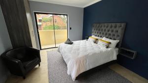 a bedroom with a large bed and a chair at MySA in Durban