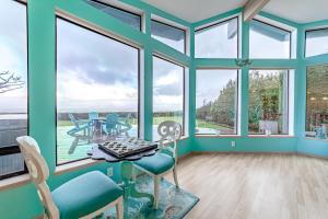 a room with large windows and a table and chairs at Mermaid Cove in McKinleyville
