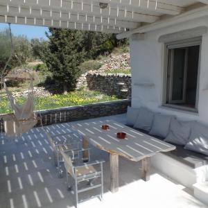 un patio con tavolo, sedie e finestra di Paros Apartments Cottage a Paroikia