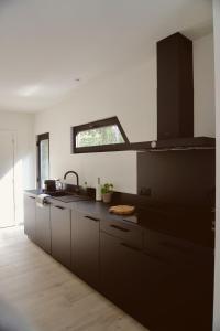a kitchen with black cabinets and a sink at Sweet Valley Madeleine in Zutendaal