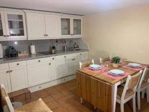 cocina con mesa de madera y armarios blancos en Vivienda turística La Caldera, en Soria