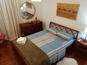 um quarto com uma cama com um espelho e uma cómoda em Maria's Cozy apartment in Palaio Faliro em Atenas