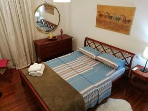 Dormitorio con cama con espejo y tocador en Maria's Cozy apartment in Palaio Faliro, en Atenas