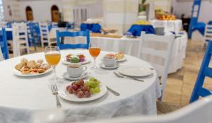 a table with plates of food and glasses of wine at Perla Del Golfo Resort in Terrasini