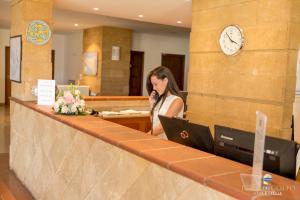 a woman sitting at a counter with a laptop at Perla Del Golfo Resort in Terrasini +71 photos