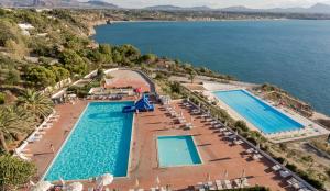 an aerial view of a pool with chairs and the water at Perla Del Golfo Resort in Terrasini