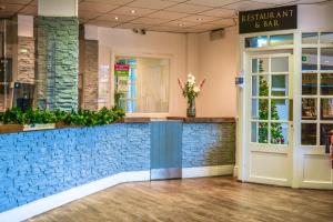 a restaurant and bar with a vase of flowers at Himley Country Hotel in Dudley