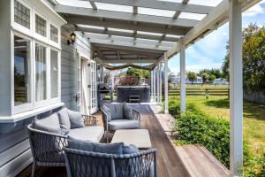 a patio with chairs and a table on a house at Brooklands Cottage in Martinborough