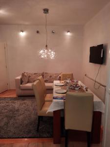 salon ze stołem i kanapą w obiekcie Stan na dan Bijeljina Tijana w mieście Bijeljina