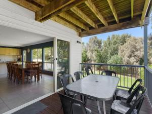 a patio with a table and chairs on a deck at Breeze on Scenic - 7 Scenic Way, Carrickalinga in Carrickalinga