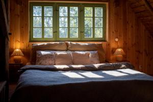 Cama en habitación con ventana en ENJOY Cozy HOME Hills & Forest & Views & Gardens & Sauna Whirlpool Bath en Jablonné v Podještědí