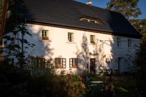 ein weißes Haus mit schwarzem Dach in der Unterkunft ENJOY Cozy HOME Hills & Forest & Views & Gardens & Sauna Whirlpool Bath in Jablonné v Podještědí