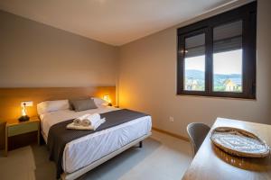 - une chambre avec un lit, une fenêtre et une table dans l'établissement APARTAMENTOS LAS OLAS BY PANTIN, à Valdoviño
