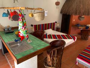 a kitchen with a table with a sink and a bed at Lo Nuestro Petit Hotel Tulum in Tulum