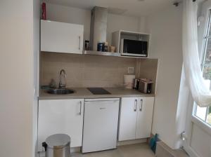 Chambre chez l'habitant في أورس: مطبخ صغير مع دواليب بيضاء وميكرويف +9 صور