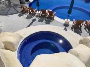 a large swimming pool with chairs and a swimming pool at La Villa de Almudena in Acapulco