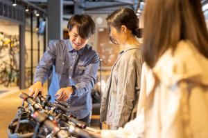 a man and woman standing in a store looking at bikes at Kona Stay Bicycle Resort in Izunokuni