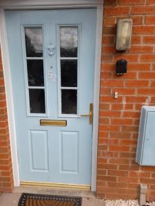 a blue front door of a brick house at Glorious BnB Longbridge in Longbridge