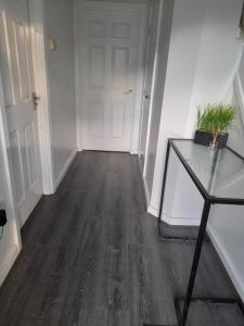 a hallway with a table and a white door at Glorious BnB Longbridge in Longbridge