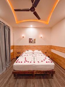 a bedroom with a large bed with roses on it at Manta Dhangethi in Dhangethi