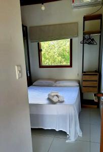 um quarto com uma cama com duas toalhas em Casa 2 Suítes com Ar, Piscina a 400 mts Praia - Taipu de Fora Barra Grande #3 em Maraú