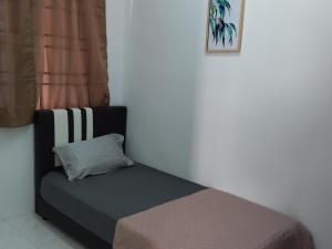 a bed in a room with a pillow on it at Pinang Beach Cottage @ Ferringhi in Batu Ferringhi