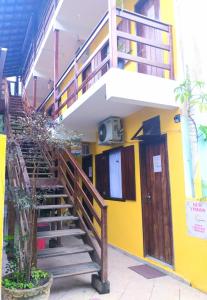 a building with a staircase and a yellow wall at SUITES COR DO SOL TRINDADE in Trindade