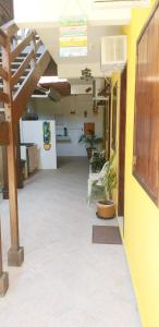 a hallway with plants in a room with a staircase at SUITES COR DO SOL TRINDADE in Trindade