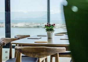 una mesa con sillas y un jarrón de flores. en Rumahku Gurney with 270 degree Sea View, en George Town