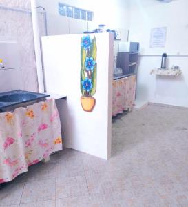 a kitchen with a refrigerator with a flower vase on it at SUITES COR DO SOL TRINDADE in Trindade