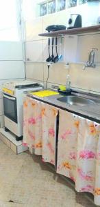 a small kitchen with a sink and a stove at SUITES COR DO SOL TRINDADE in Trindade