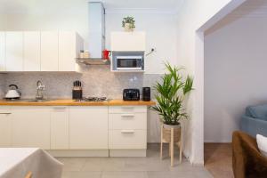 a kitchen with white cabinets and a microwave at Arcadia Apartment - Cottesloe in Perth