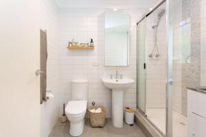 a bathroom with a toilet and a sink and a shower at Arcadia Apartment - Cottesloe in Perth +11 photos