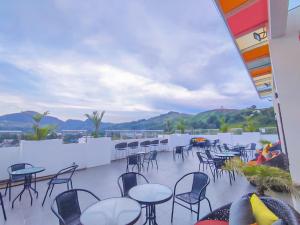 a patio with tables and chairs on a balcony at Front One Budget Waena Abepura in Abepura