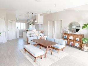 een keuken en een woonkamer met een tafel en stoelen bij Guesthouse Koa in Miyako Island
