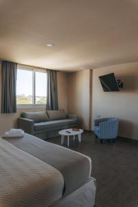 una habitación de hotel con una cama y un sofá en Solana - Apart Hotel & Club de Tenis, en Santa Clara del Mar