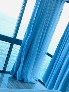 a blue curtain in a room with a window at Malecón vista mar Habitación Privada Larimar, in Santo Domingo