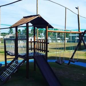 a playground with a swing set in a park at Muro Alto Condomínio Clube Térreo 106 in Porto De Galinhas