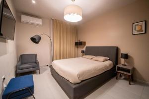 - une chambre avec un lit et une chaise dans l'établissement PENINSULA STAYS 2 BR Designer Apartment & 200 MB FAST WIFI New Listing!, à Mérida