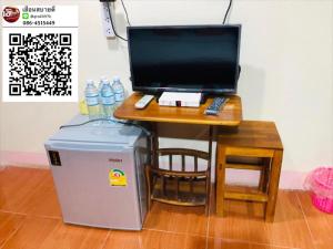 Huen Sabaidee Soi 8 في تشيانغ خان: مكتب فيه كمبيوتر وطاولة عليها زجاجات الماء