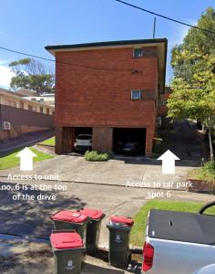 a group of trash cans in front of a building at 2 Bed Bar Beach Apartment - stroll to beach & cafes, supermarket apartment number 6 in Newcastle