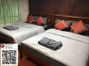 two beds in a hotel room with towels on them at Huen Sabaidee Soi 8 in Chiang Khan