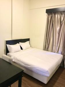 a bed with white sheets in a room with a window at Taman Air Lagoon Resort at A921, unlimited waterpark access, Melaka in Melaka